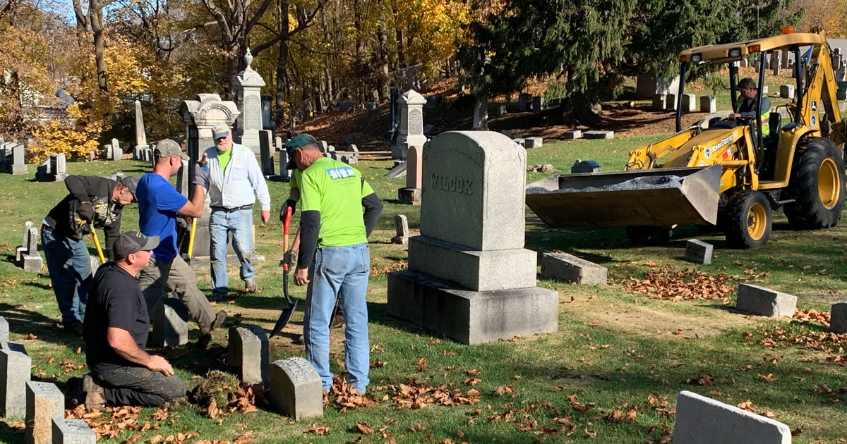 volunteers re-setting gravestones